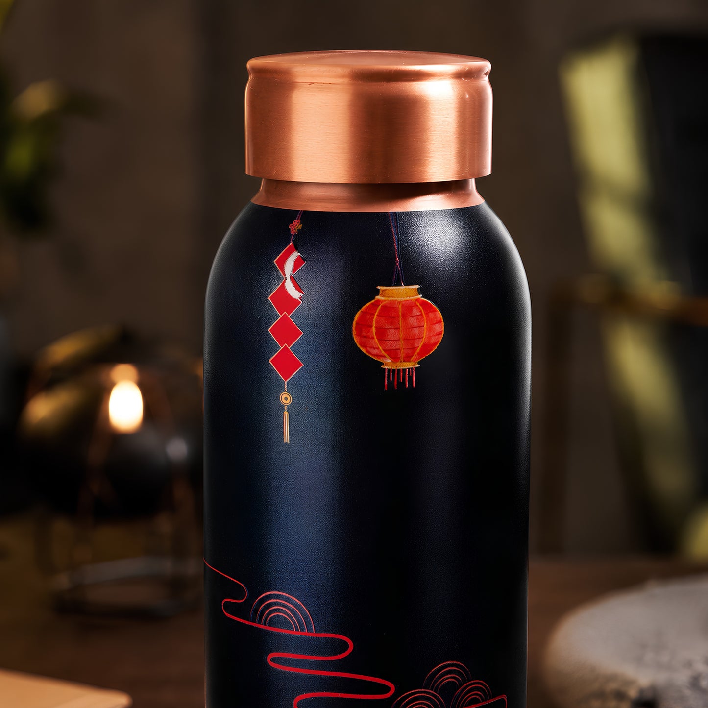 Red fan UV embossed design closeup on Tamrit black copper bottle