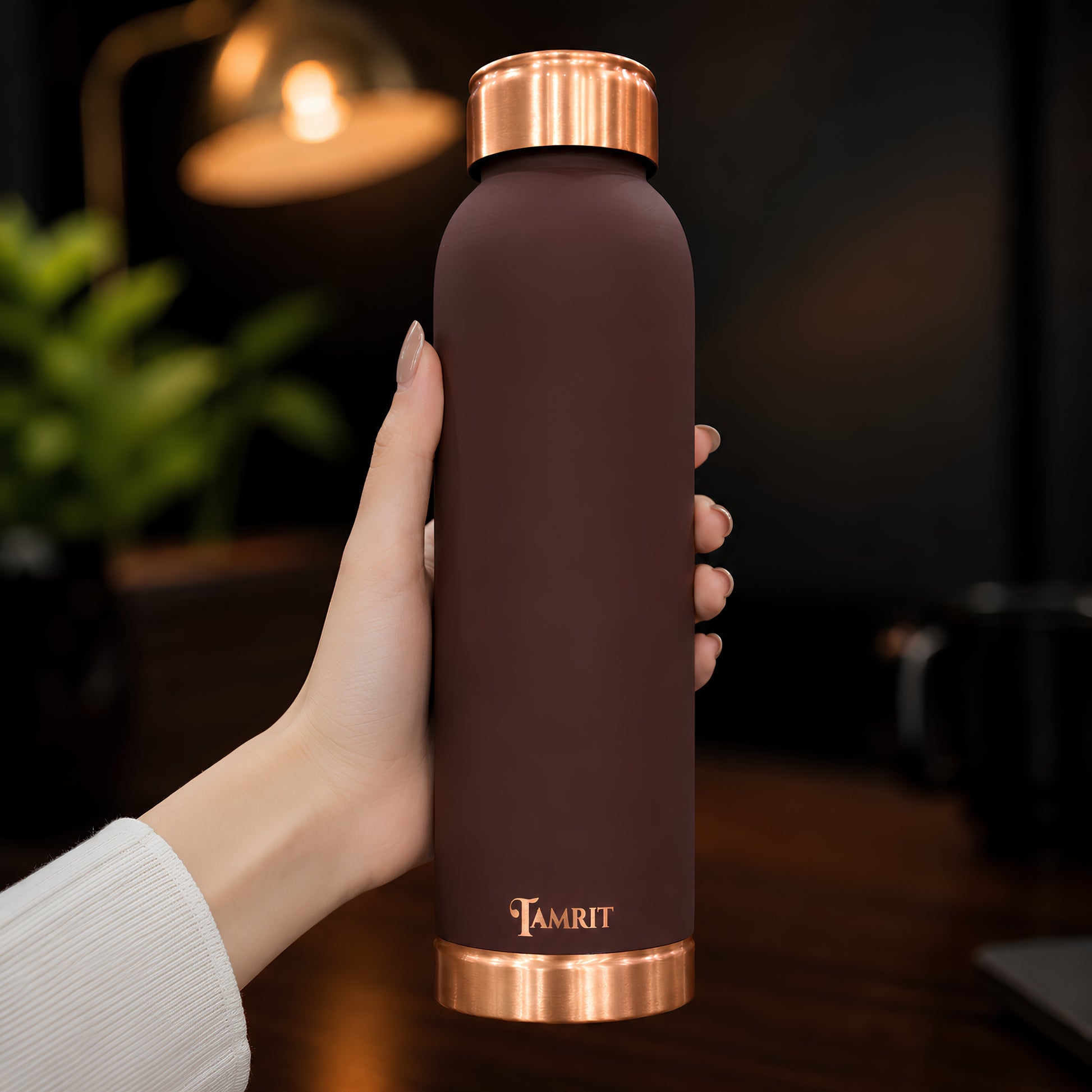 Tamrit brown copper bottle held in hand, showing matte finish