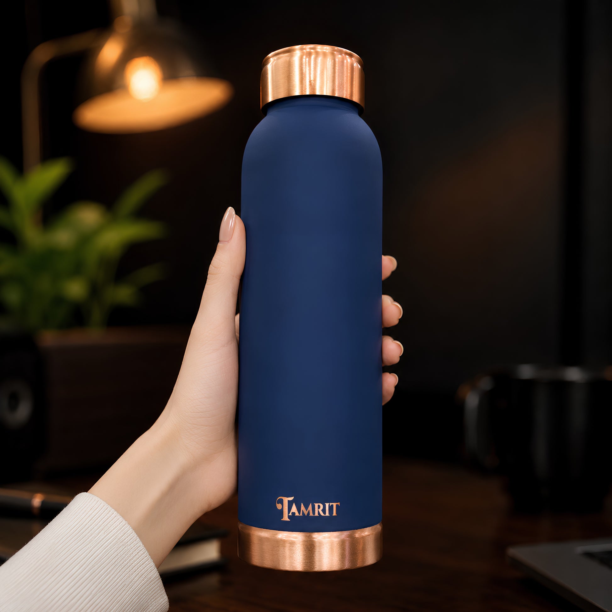 Tamrit blue copper bottle held in hand, showing premium finish